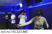 Portrait of happy excited young girl with VR glasses on head, holding handheld controllers playing virtual reality game with friends. Стоковое видео, видеограф Яков Филимонов / Фотобанк Лори