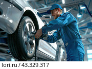 The mechanic removes the wheel from the car for repair. Стоковое AI-изображение, AI-художник Ярославский Максим / Фотобанк Лори