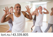 Latin american dancer practicing synchronous choreography with group. Стоковое фото, фотограф Яков Филимонов / Фотобанк Лори
