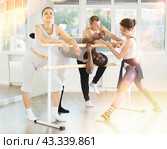 African American man goofing around by ballet barre with fellow dancers in studio. Стоковое фото, фотограф Яков Филимонов / Фотобанк Лори