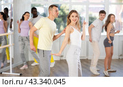 Cheerful young adult couple dancing lindy hop at dance rehearsal. Стоковое фото, фотограф Яков Филимонов / Фотобанк Лори