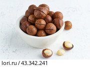 Plate with almonds in endocarp, whole and chopped open nuts. Стоковое фото, фотограф Natalia Gdovskaia / Фотобанк Лори