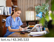 Young woman therapist working with case histories on laptop in office. Стоковое фото, фотограф Яков Филимонов / Фотобанк Лори