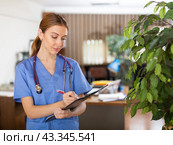 Nurse standing in hall with clipboard in hands. Стоковое фото, фотограф Яков Филимонов / Фотобанк Лори
