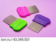 Three combs for removing lice and nits on lilac background. Стоковое фото, фотограф Сергей Толмачёв / Фотобанк Лори