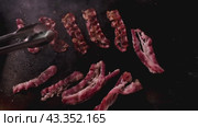 Bacon sizzling on a hot griddle, creating a delightful aroma and crispy texture. Стоковое видео, видеограф Victor Kaprov / Фотобанк Лори