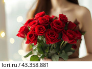 A beautiful bouquet of pastel rad roses in female hands. Work as a florist in a flower shop. Delivery of fresh cut flowers. European flower shop. Beautiful girl holding a bouquet of rad roses. Стоковое AI-изображение, AI-художник Евгений Демидюк / Фотобанк Лори