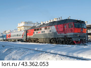 Российский тепловоз ТЭП70 с пассажирским поездом на станиции Рыбинск солнечным январским днем (2024 год). Редакционное фото, фотограф Виктор Карасев / Фотобанк Лори