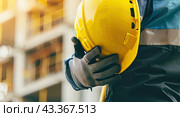A banner with a builder holding a helmet on the background of a new building. Copy space. Стоковое AI-изображение, AI-художник Ярославский Максим / Фотобанк Лори