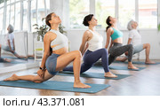 Young girl performing Crescent Moon Pose Anjaneyasana in yoga studio. Стоковое фото, фотограф Яков Филимонов / Фотобанк Лори