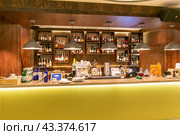 Bar counter in a modern restaurant. Bottles of alcohol behind the bar (2023 год). Редакционное фото, фотограф Евгений Ткачёв / Фотобанк Лори