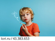 Мальчик в оранжевой футболке с сигаретой на голубом фоне. Стоковое AI-изображение, AI-художник Щеголева Ольга / Фотобанк Лори