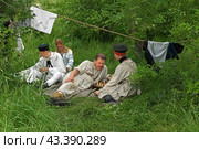 Historical reconstruction in beautiful historical and authentic costumes at festival Times and Epochs in Moscow. Actors relax on green meadow (2024 год). Редакционное фото, фотограф Валерия Попова / Фотобанк Лори