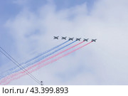 Воздушная часть парада Победы ВОВ в Москве, шестерка самолетов-штурмовиков Су-25БМ выпуск триколора Российского флага при пролете над Тверской, над крышами домов (2024 год). Редакционное фото, фотограф Елизавета Корнилова / Фотобанк Лори
