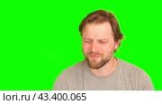 Upset man over plain green background. Adult bearded fun confused shy shamed bemused guy. Green screen chromakey. Handsome sad male looking dissatisfied sadness isolated greenscreen. Expressing sorrow. Стоковое видео, видеограф Марина Демидюк / Фотобанк Лори