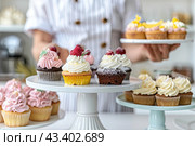 An unrecognized pastry chef girl offers visitors to taste her products. Стоковое AI-изображение, AI-художник Ярославский Максим / Фотобанк Лори
