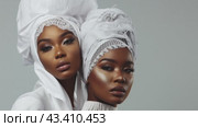 Two women wearing white turbans exude happiness and elegance at a special occasion. Стоковое AI-видео, аниматор Юрий Поздников / Фотобанк Лори