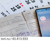 Сведения о заработной плате и стаже в личном кабинете гражданина. Страницы трудовых книжек на фоне календаря и электронные приложения Государственные услуги и Налоги ФЛ. (2024 год). Редакционное фото, фотограф Татьяна Т / Фотобанк Лори