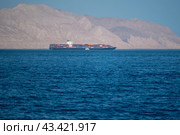 Bukha, OMAN - MAY 28 2021: Iranian coastline near the Strait of Hormuz. giant sea container ship in the strait of Hormuz. Редакционное фото, фотограф Павел Муравьев / Фотобанк Лори