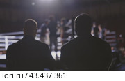 Two men stand in a boxing ring, watching a match. Стоковое видео, видеограф Константин Шишкин / Фотобанк Лори