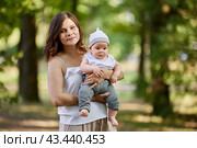 Young mother with nursing baby in her arms in public park. Стоковое фото, фотограф Владимир Григорьев / Фотобанк Лори