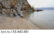 Video of Baikal Lake on Autumn.  Sandy beach of Olkhon Island on October. Beautiful autumn landscape with yellowed bushes on steep cliffs. Natural seasonal background. Travel and outdoor recreation. Стоковое видео, видеограф Виктория Катьянова / Фотобанк Лори