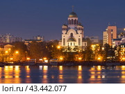 Город Екатеринбург, Свердловская область, Россия. Вид со стороны реки Исеть на Храм-Памятник на Крови Во имя всех Святых в Земле Российской Просиявших. Православный храм в Екатеринбурге, построенный на месте дома, в котором содержались под арестом и были расстреляны в ночь на 17 июля 1918 года последний российский император Николай II и его семья. Вечерний городской пейзаж с красивой большой христианской церковью. Стоковое фото, фотограф Андрей Степанов / Фотобанк Лори
