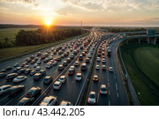 Aerial view of cars on road highway in traffic jam at sunset background. Traffic jam rush hour, cars in line, bumper to bumper, stuck in traffic at dusk. Urban transport concept. Copy ad text space. Стоковое AI-изображение, AI-художник Aleksandr Golubev / Фотобанк Лори