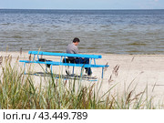 Одинокая фигура мужчины, сидящего у моря (2012 год). Редакционное фото, фотограф Лариса Гордеева / Фотобанк Лори