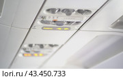 A view of the buttons located on the ceiling of a passenger aircraft, where safety elements such as an oxygen mask are located. With space to copy. Стоковое видео, видеограф Darya Komarova / Фотобанк Лори