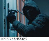 Masked Intruder Attempting to Break In. Стоковое AI-изображение, AI-художник Кирилл Черезов / Фотобанк Лори