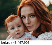 A mother lovingly gazes at her infant baby, holding the child close in her arms. Cute infant child is calm. Love of mother and child. Happy childhood. Family relationships, motherhood and fertility. Стоковое AI-изображение, AI-художник Юлия Петровская / Фотобанк Лори