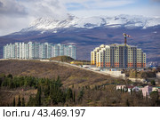 Многоэтажные новостройки Алушты на фоне зимнего Чатыр-Дага (2024 год). Стоковое фото, фотограф Oles Kolodyazhnyy / Фотобанк Лори