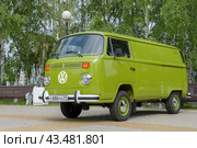 Side view of a green retro Volkswagen Kombi bus (T2) parked on tiles in a park. Cheboksary, Russia. 6/15/2024. Редакционное фото, фотограф Alexander / Фотобанк Лори
