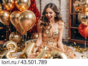 A party. A beautiful, happy girl in a stylish festive dress surrounded by gold confetti and sequins. The concept of celebrating a birthday and a happy new year. Close-up. Стоковое AI-изображение, AI-художник Photojuli / Фотобанк Лори