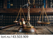 Justice and the law. A wooden hammer, books and scales on the table. The court session. Стоковое AI-изображение, AI-художник Photojuli / Фотобанк Лори