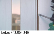 Foaming cracks in the door frame with mounting foam. Construction and repair. Installation and fastening of a wooden frame. Стоковое видео, видеограф Дмитрий Кобзев / Фотобанк Лори