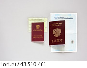 Личные документы пожилого человека - паспорт гражданина России, пенсионное удостоверение, страховое свидетельство СНИЛС и полис обязательного медицинского страхования на светлом столе (2024 год). Редакционное фото, фотограф Виктория Катьянова / Фотобанк Лори