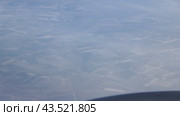 The plane has gained an altitude of 5,000 meters and is flying in a small haze. Flight Volgograd-Moscow. The snow-covered ground is visible through the porthole. Стоковое видео, видеограф Андрей Жигальцов / Фотобанк Лори