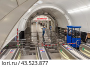 Работник метрополитена в каске наблюдает за работающими эскалаторами. Открытая после реконструкции станция метро «Чернышевская» в Санкт-Петербурге (2024 год). Редакционное фото, фотограф Румянцева Наталия / Фотобанк Лори