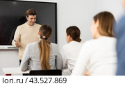 Male trainer near interactive board conducting advanced training courses to office employees sitting at desks in auditory. Стоковое фото, фотограф Яков Филимонов / Фотобанк Лори