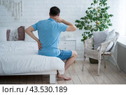 Lumbar and cervical spine hernia, man with back pain at home, compression injury of the intervertebral disc. Стоковое фото, фотограф Станислав Тарко / Фотобанк Лори