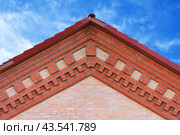 Fragment of a brick gable with decorative frieze on a blue sky background. Стоковое фото, фотограф Михаил Строгалев / Фотобанк Лори