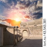 Roman Theatre in Amman, Jordan -- theatre was built the reign of Antonius Pius (138-161 CE), the large and steeply raked structure could seat about 6000 people. Against the sky with clouds (2016 год). Стоковое фото, фотограф Владимир Журавлев / Фотобанк Лори