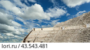 Roman Theatre in Amman, Jordan -- theatre was built the reign of Antonius Pius (138-161 CE), the large and steeply raked structure could seat about 6000 people. Against the sky with clouds (2016 год). Стоковое фото, фотограф Владимир Журавлев / Фотобанк Лори