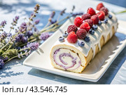 Swiss sponge roll with raspberries, a delicious fruit and cream dessert filled with cream cheese, decorated with fresh raspberries. Стоковое AI-изображение, AI-художник Photojuli / Фотобанк Лори
