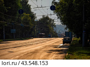 Улица города с трамвайными путями ранним утром, залитая золотым светом Солнца (2024 год). Редакционное фото, фотограф Илья Старков / Фотобанк Лори