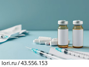Syringe and glass vial on blue background table. Medical Vials group, needles, ampoules, bottle with medicines or vaccine. Disease treatment. Creative Banner. Anti-aging beauty injections. Vaccination. Стоковое AI-изображение, AI-художник Марина Демидюк / Фотобанк Лори
