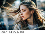 A beautiful, young woman with a thoughtful look. The hair develops in the wind and gives a feeling of lightness and naturalness. Стоковое AI-изображение, AI-художник Photojuli / Фотобанк Лори