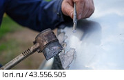 Car body shop. Repair man processes the welding seam using an angle grinder on replaced car part. Professional Body master grind old paint and rust. Rust damage. Rusting car. Hands with tool close-up. Стоковое видео, видеограф Марина Демидюк / Фотобанк Лори